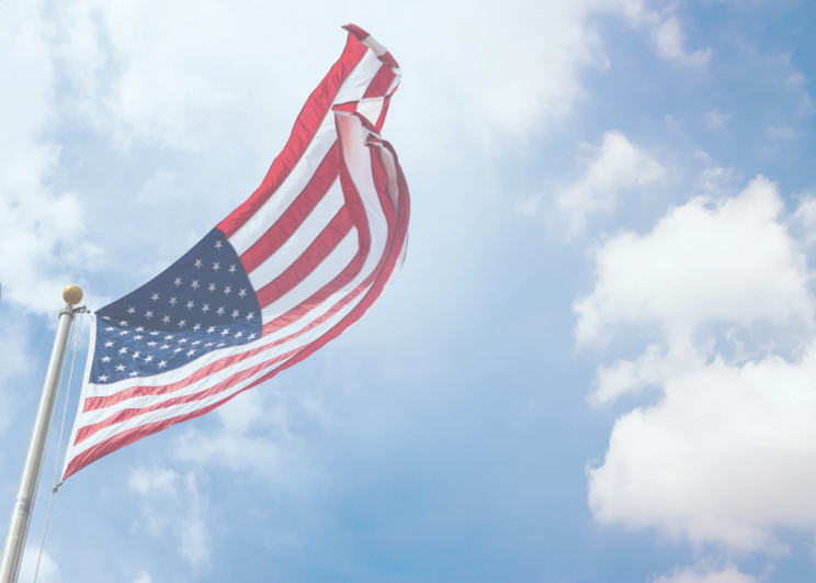 American flag flying in front of cloudy sky
